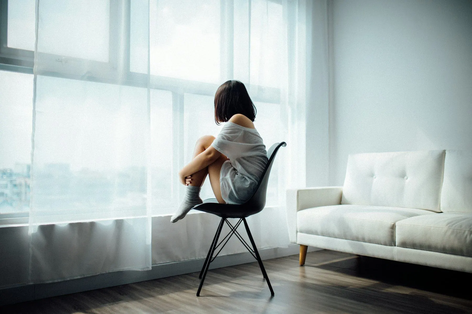 Femme pensive près d’une fenêtre